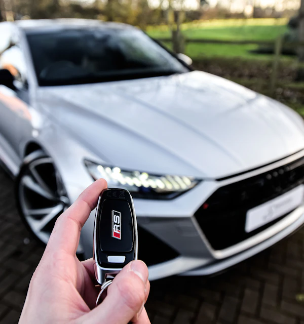 Autoschlüssel vor einem silbernen Auto