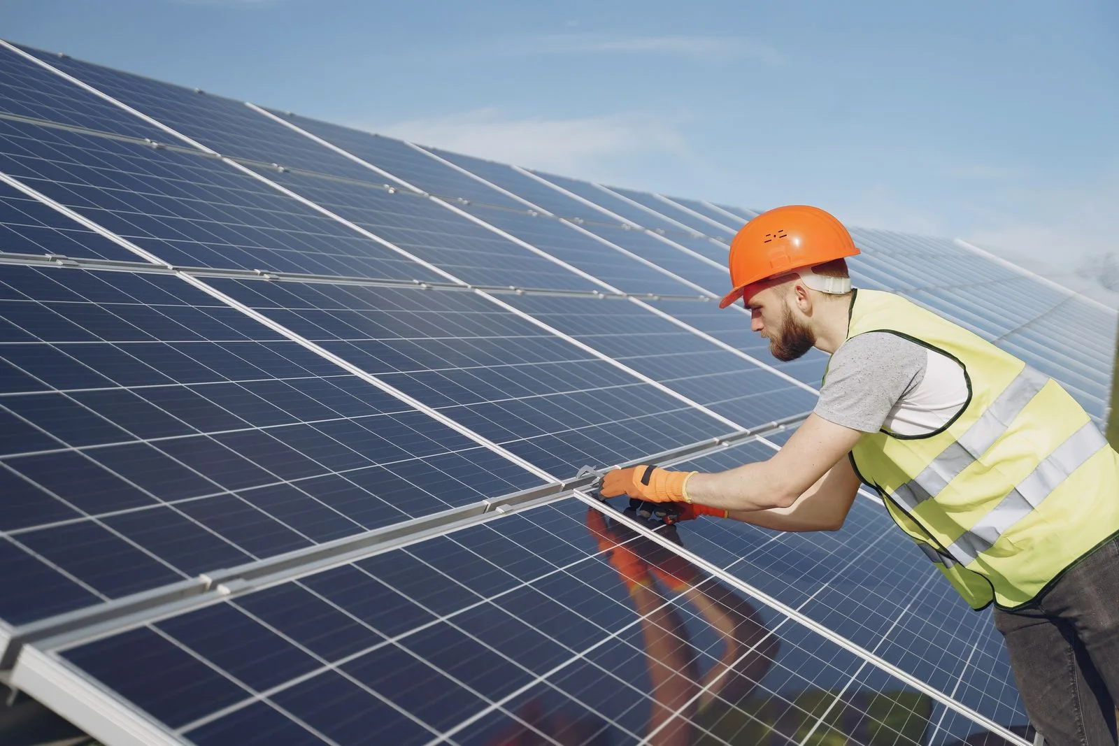 Fachkraft installiert Solarmodule bei Tageslicht