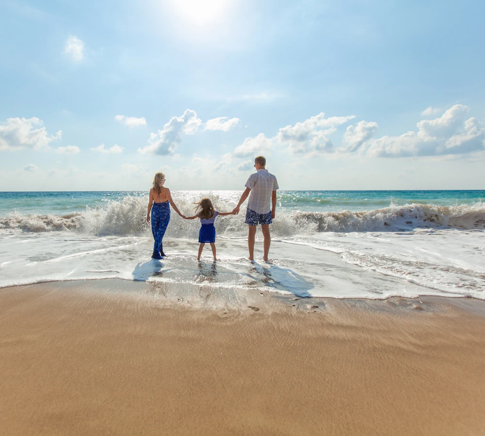 Familie geht Hand in Hand am Strand