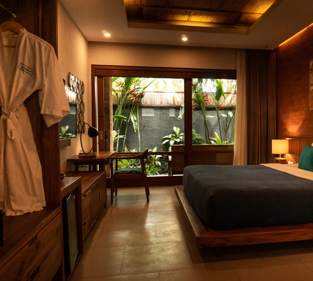 Hotelzimmer mit Holzbett und Gartenblick