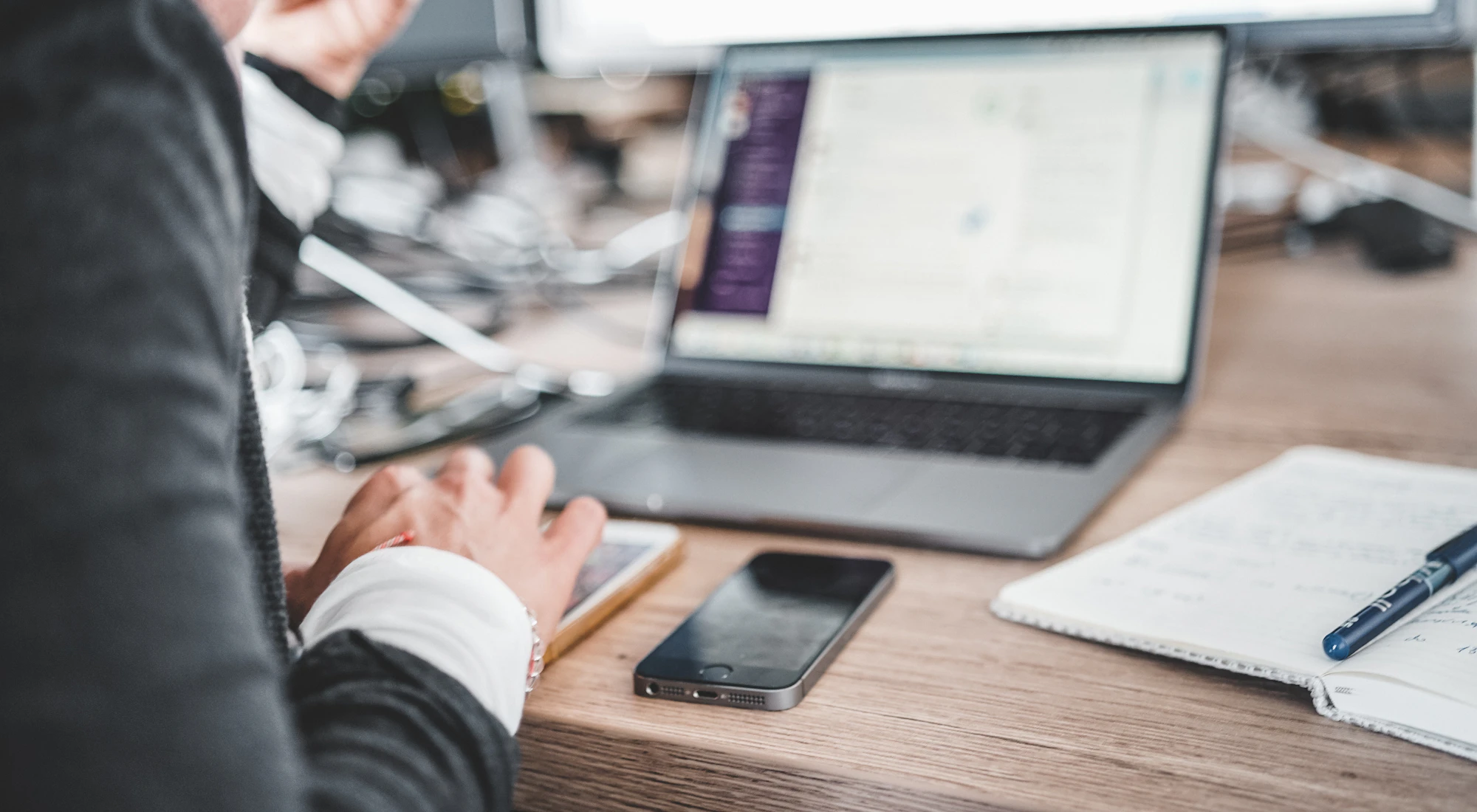 Smartphone neben einem Laptop am Arbeitsplatz
