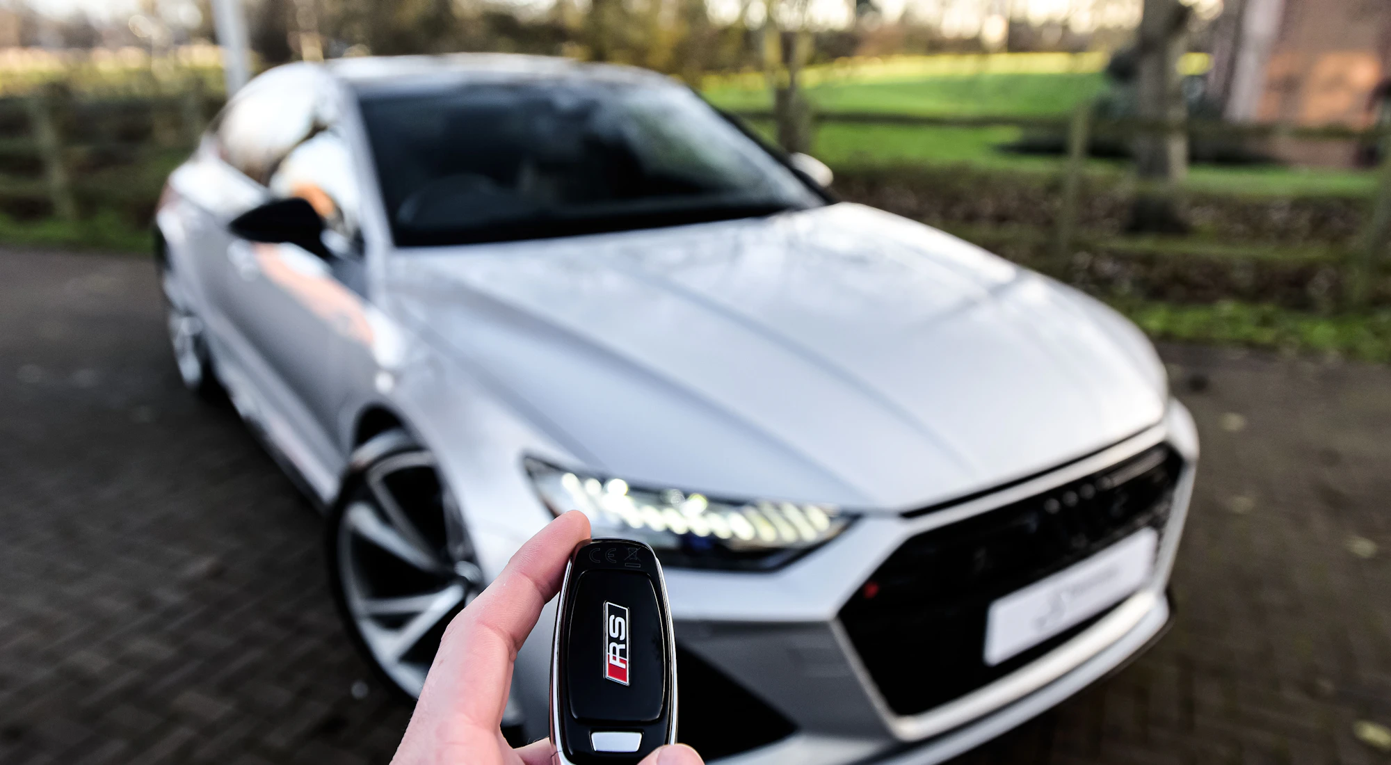 Autoschlüssel vor einem silbernen Auto