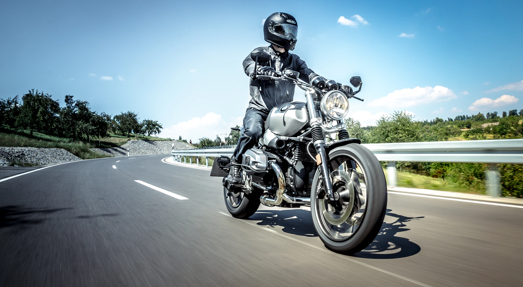 Motorradfahrer mit Helm auf einer Landstraße