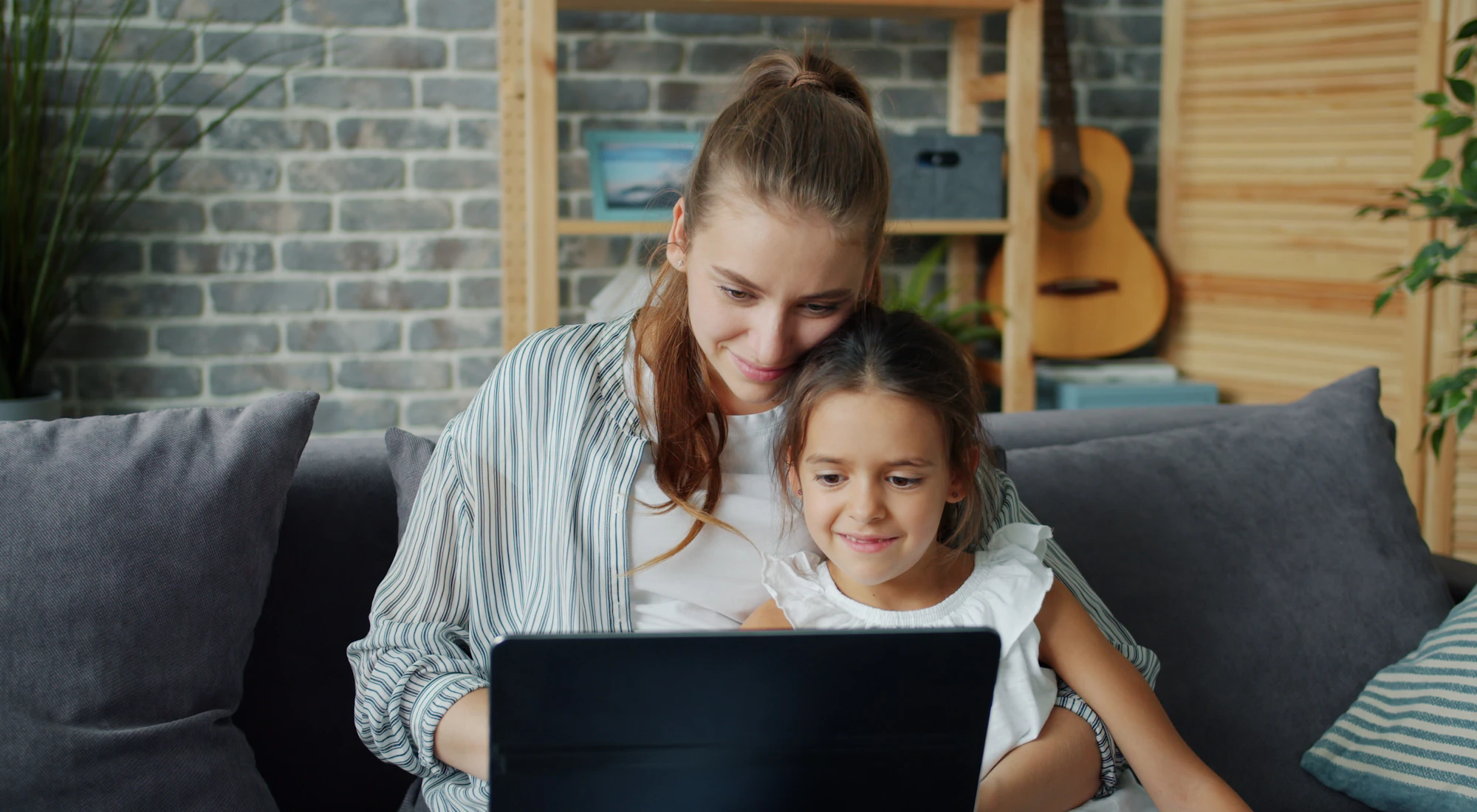 Mutter und Tochter schauen gemeinsam auf den Laptop