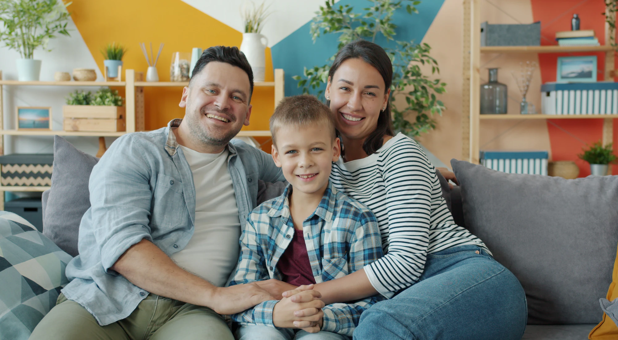Fröhliche Familie sitzt zu Hause auf dem Sofa