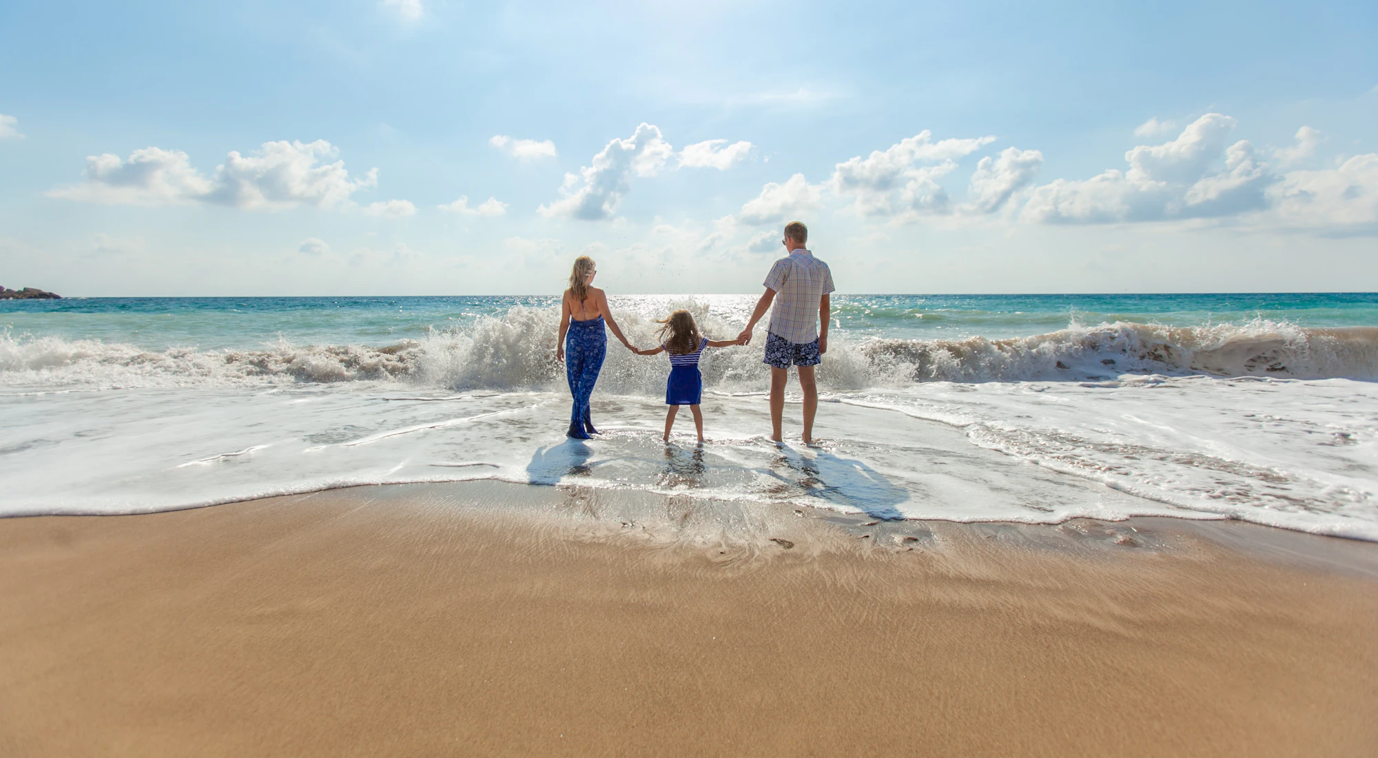 Familie geht Hand in Hand am Strand