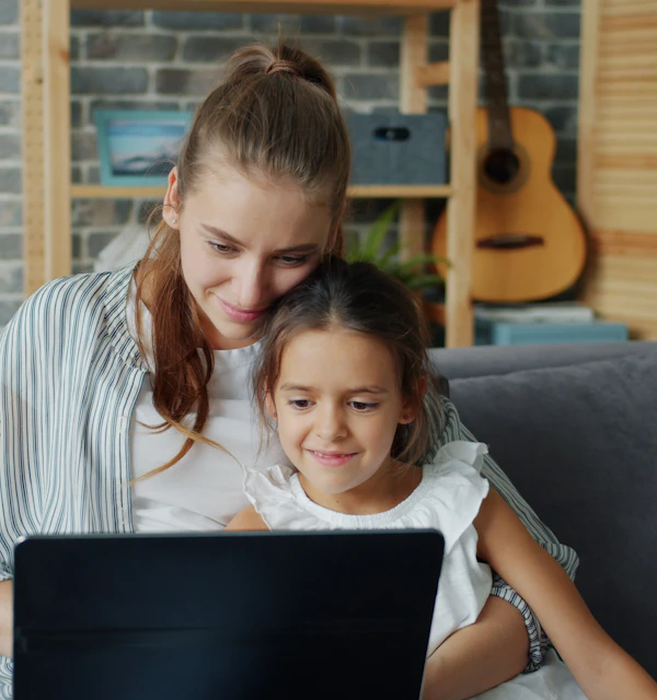 Mutter und Tochter schauen gemeinsam auf den Laptop
